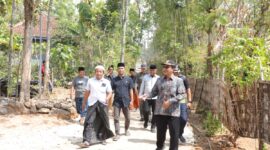 FOTO : Bupati Pamekasan, Dr. KH. Kholilurrahman, didampingi perangkat desa dan tokoh masyarakat meninjau langsung lokasi perbaikan jalan swadaya sepanjang 1,7 km di Dusun Sakante dan Dusun Durbugan, Desa Campor, Kecamatan Proppo, Sabtu (15/8/2026). Dalam kunjungan tersebut, Bupati juga menyerahkan bantuan pribadi untuk mendukung kegiatan gotong royong warga.
