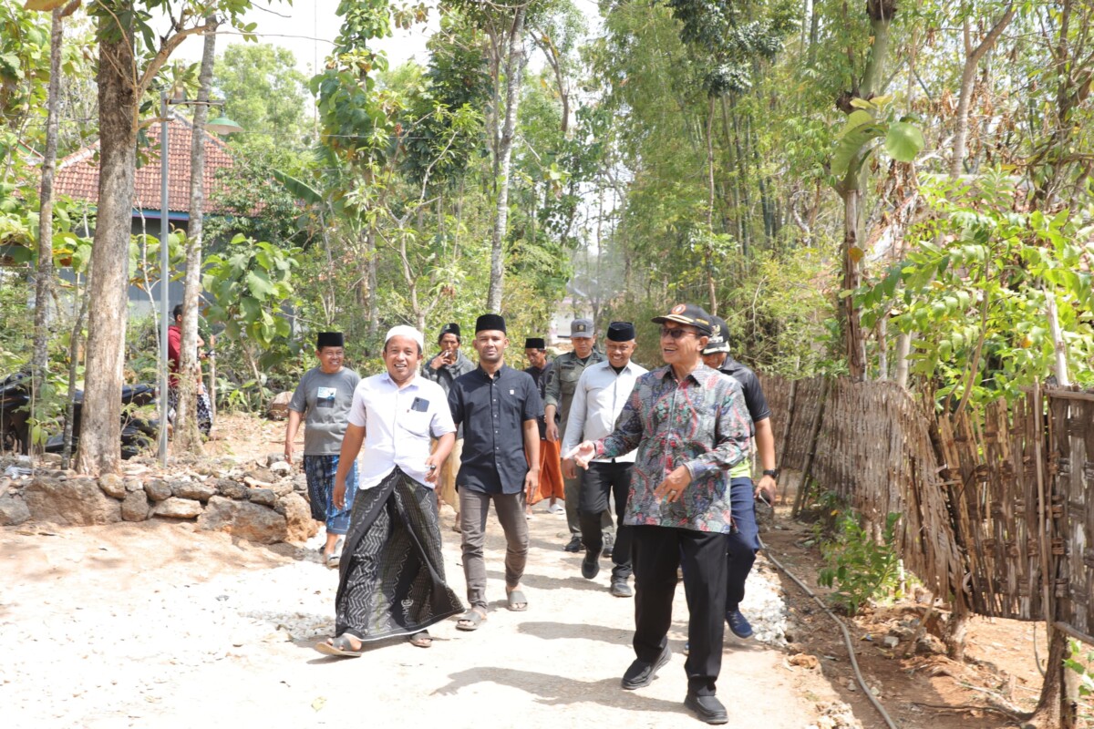 FOTO : Bupati Pamekasan, Dr. KH. Kholilurrahman, didampingi perangkat desa dan tokoh masyarakat meninjau langsung lokasi perbaikan jalan swadaya sepanjang 1,7 km di Dusun Sakante dan Dusun Durbugan, Desa Campor, Kecamatan Proppo, Sabtu (15/8/2026). Dalam kunjungan tersebut, Bupati juga menyerahkan bantuan pribadi untuk mendukung kegiatan gotong royong warga.